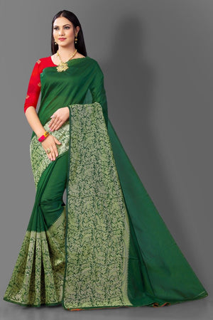 Woman wearing a green saree with red blouse on a gray background