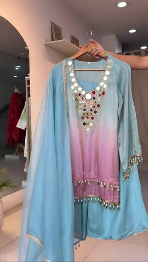 Light blue and pink traditional outfit with embellishments on a hanger.