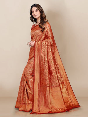 Woman wearing an orange saree with a gold border on a beige background
