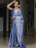 Woman wearing a blue saree with a blurred indoor background