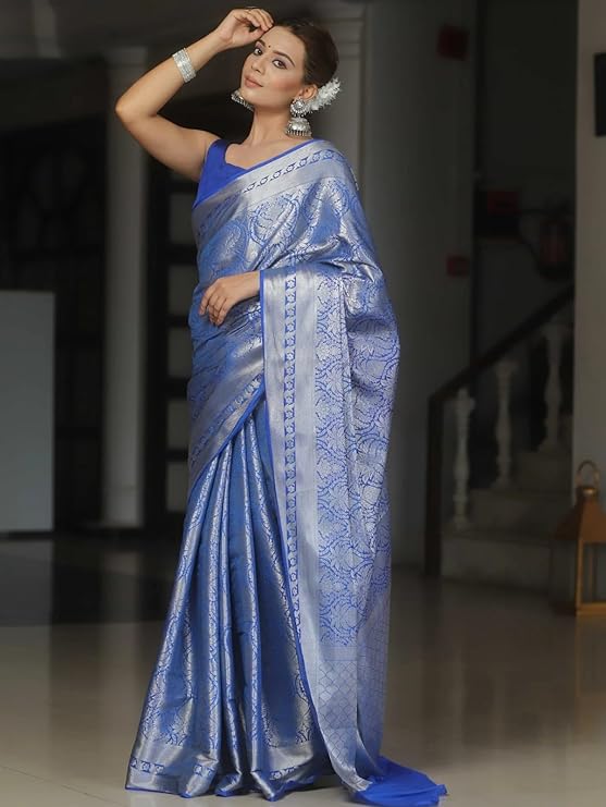 Woman wearing a blue saree with a blurred indoor background