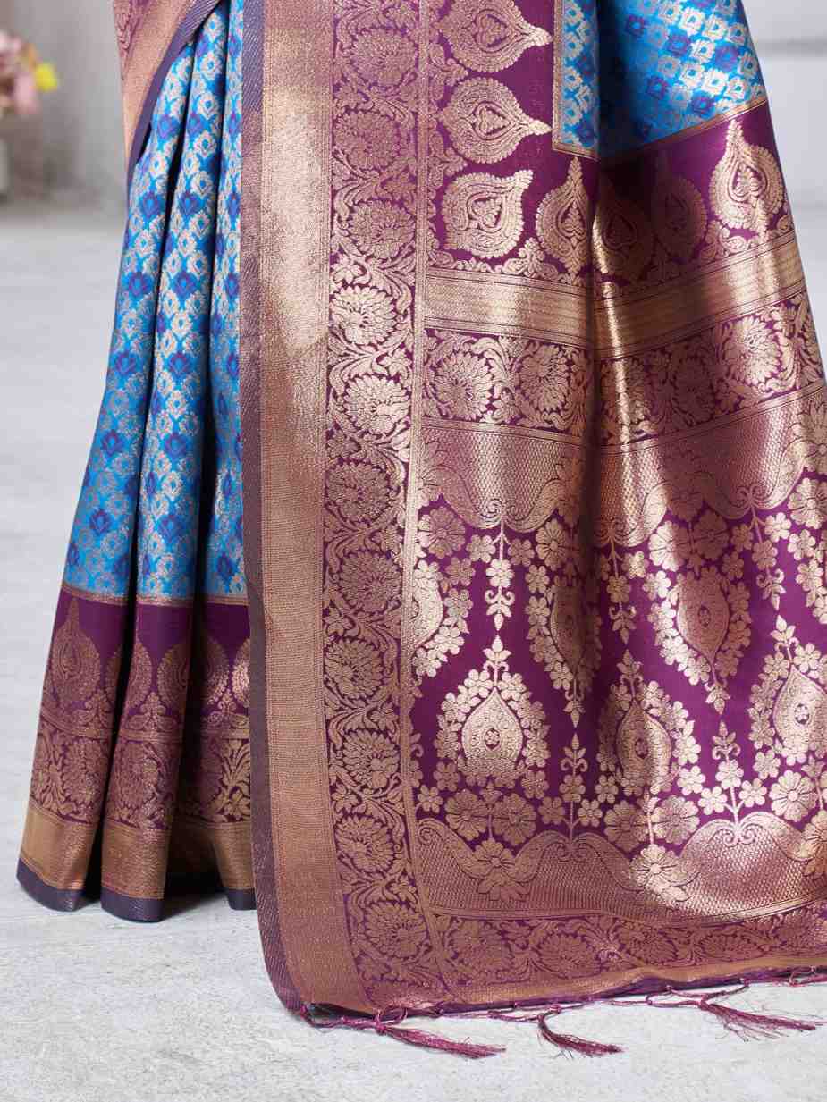Close-up of a traditional saree with intricate patterns and colors on a light background