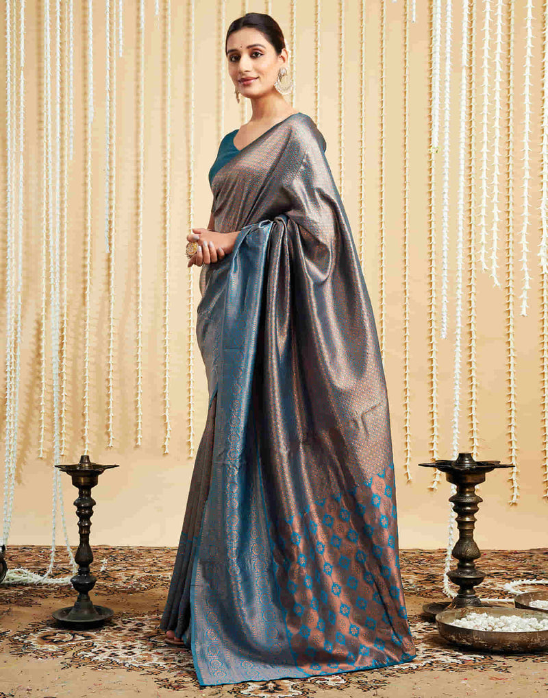 Woman wearing a gray and blue saree with a decorative background