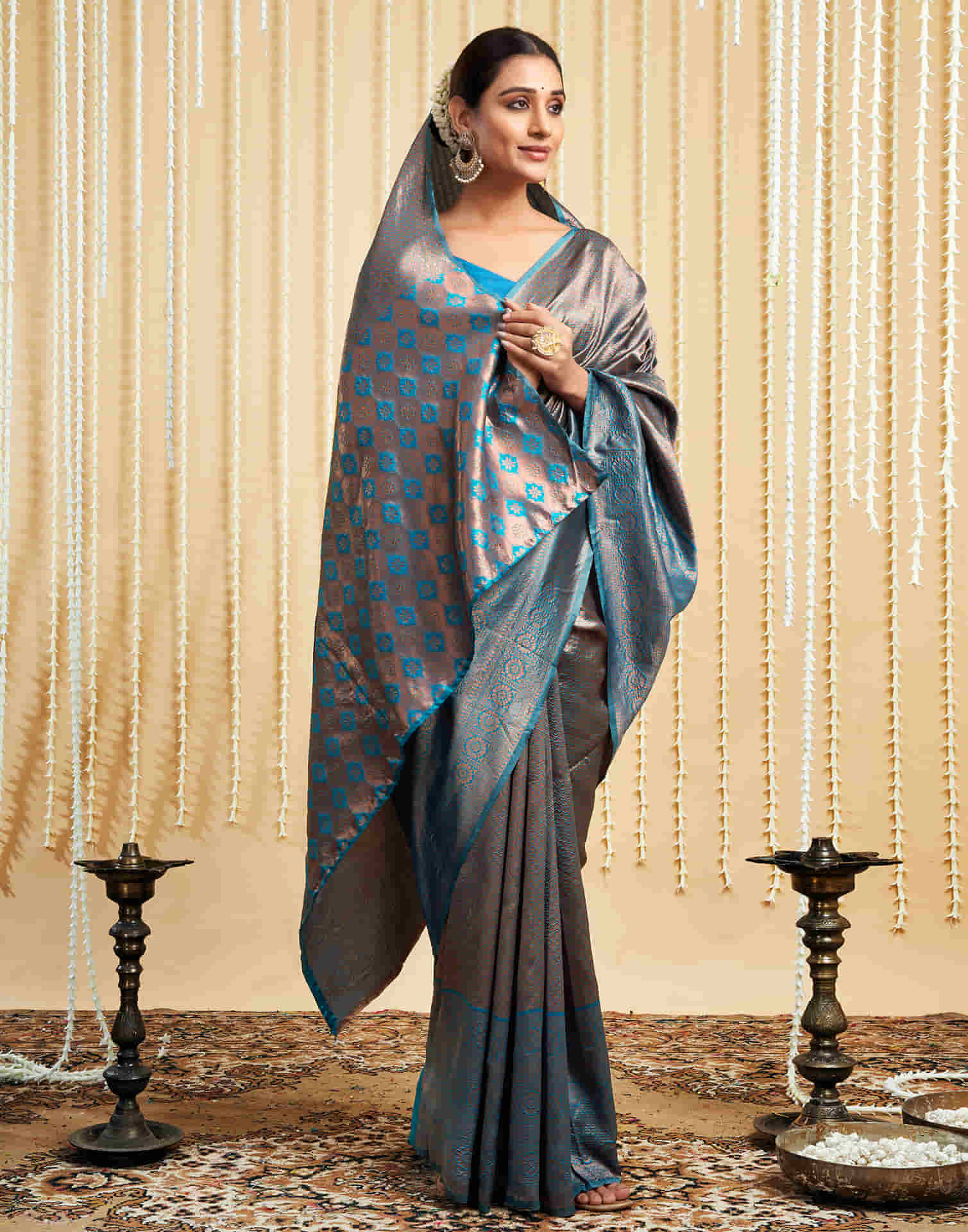 Woman wearing a traditional saree with a checkered pattern against a decorative background