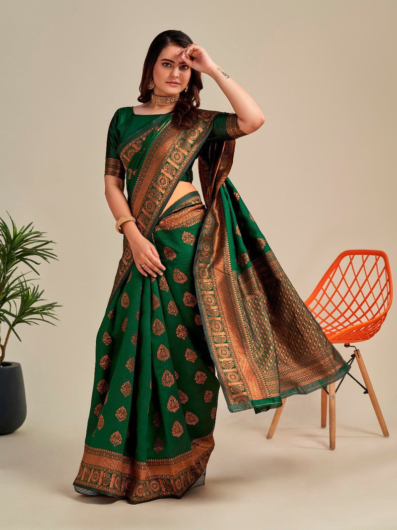Woman wearing a green and brown saree with a neutral background