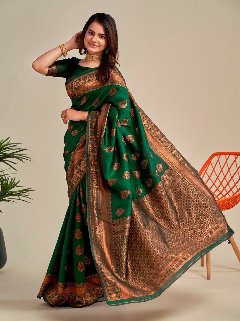 Woman wearing a green and brown saree with a neutral background