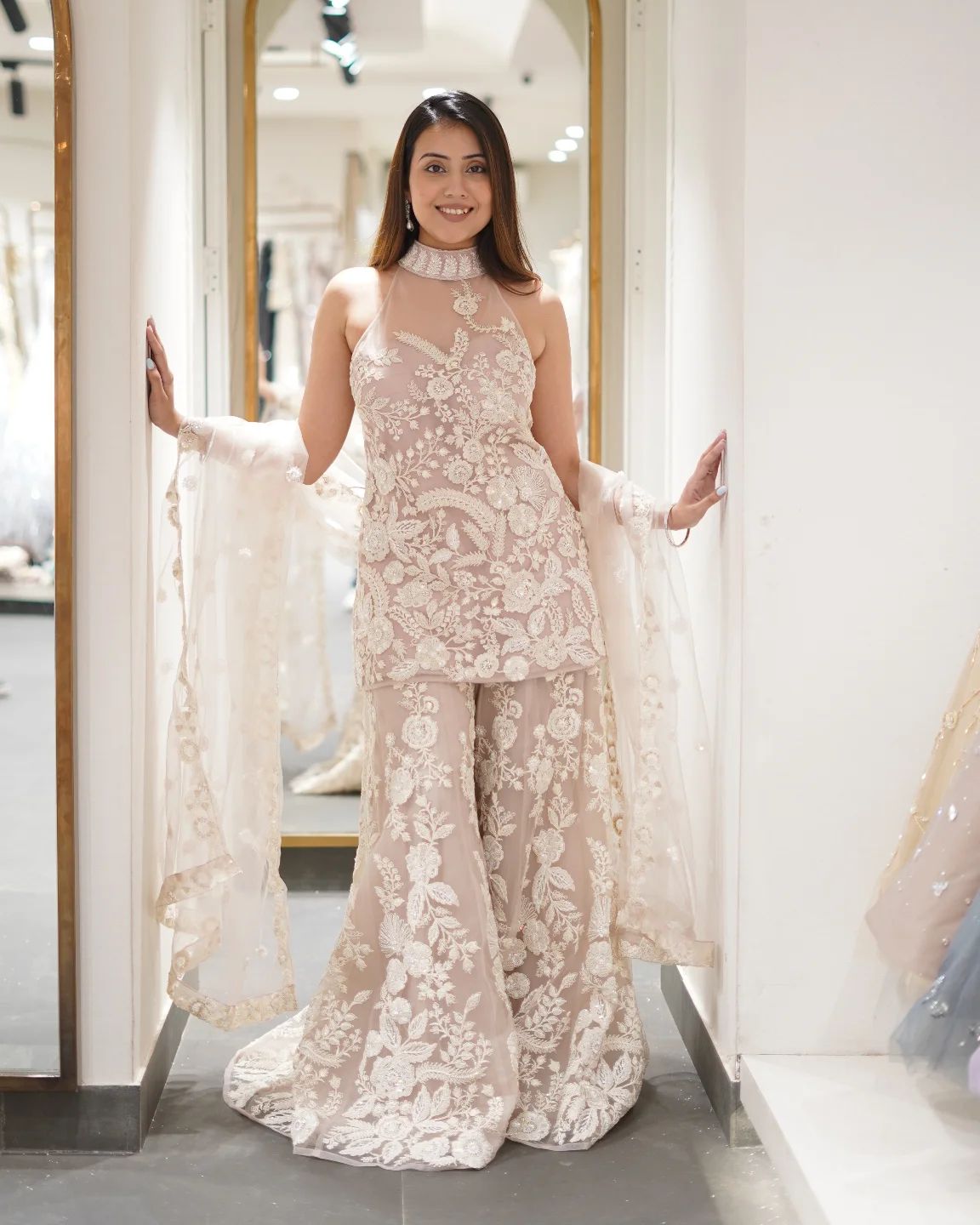 Woman wearing a floral lace outfit standing in front of a mirror.