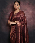 Woman wearing a maroon saree with a dark background