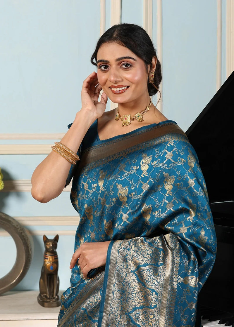Woman in a blue saree standing next to a piano in an elegant room.