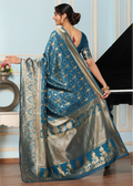 Woman wearing a blue and silver saree in an indoor setting