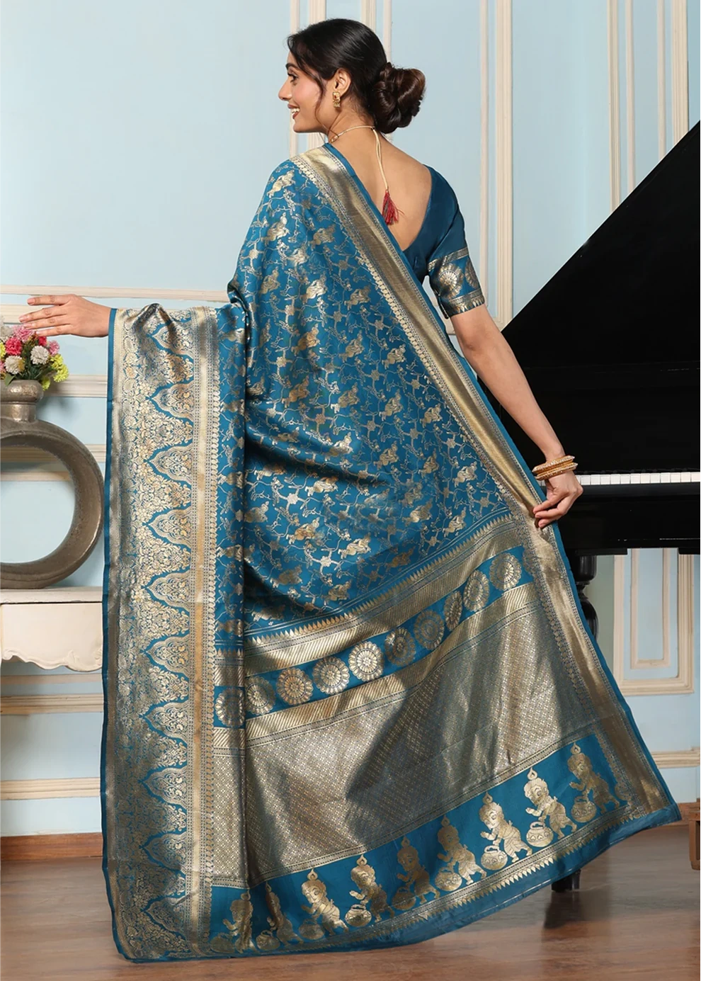 Woman wearing a blue and silver saree in an indoor setting
