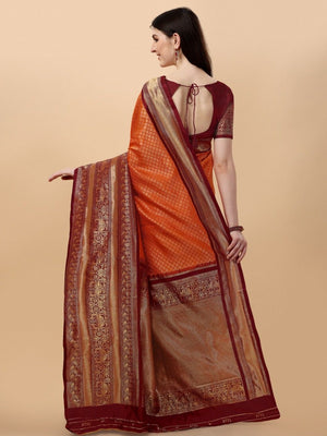 Woman wearing an orange saree with a brown border on a beige background