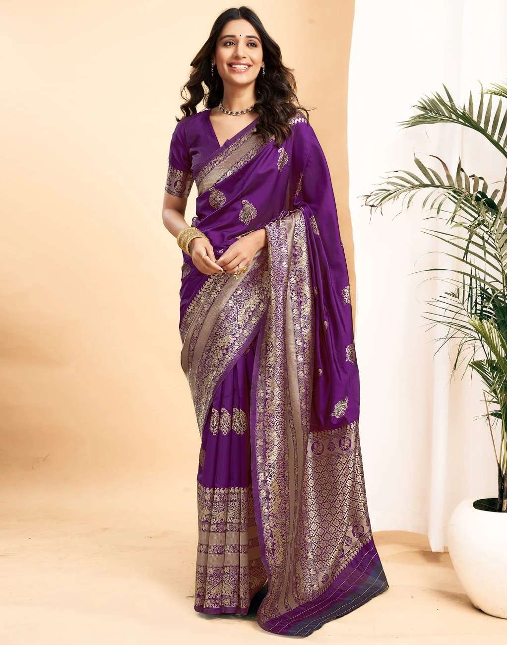 Woman wearing a purple saree with a plant in the background