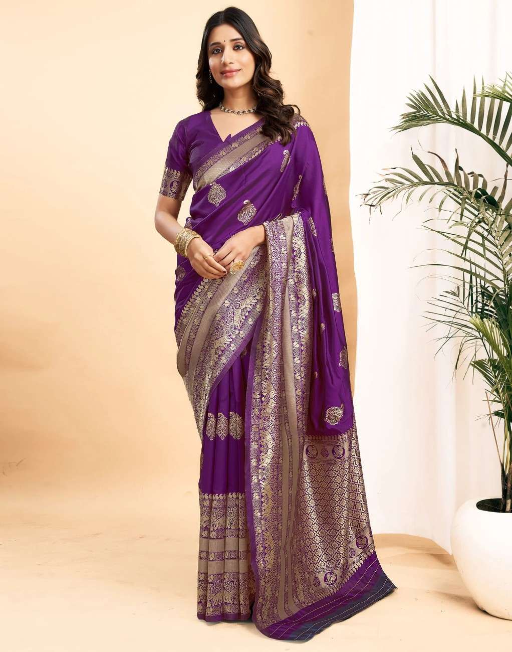 Woman wearing a purple saree with a plant in the background