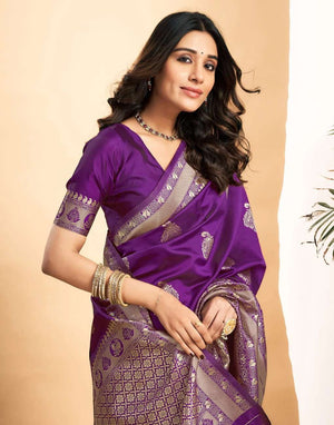 Woman wearing a purple saree with silver patterns on a beige background