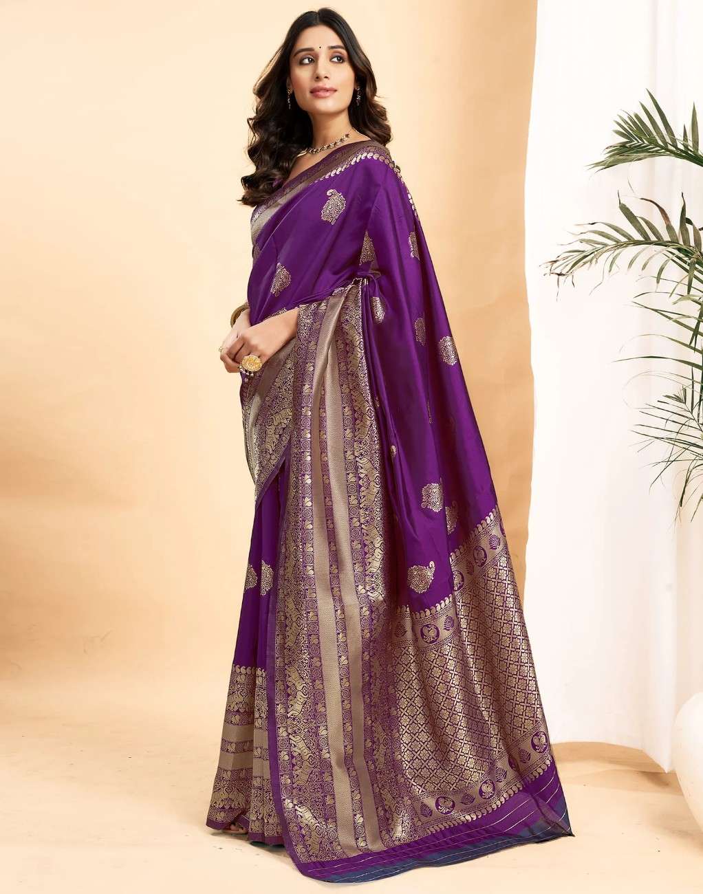 Woman wearing a purple saree with a beige background