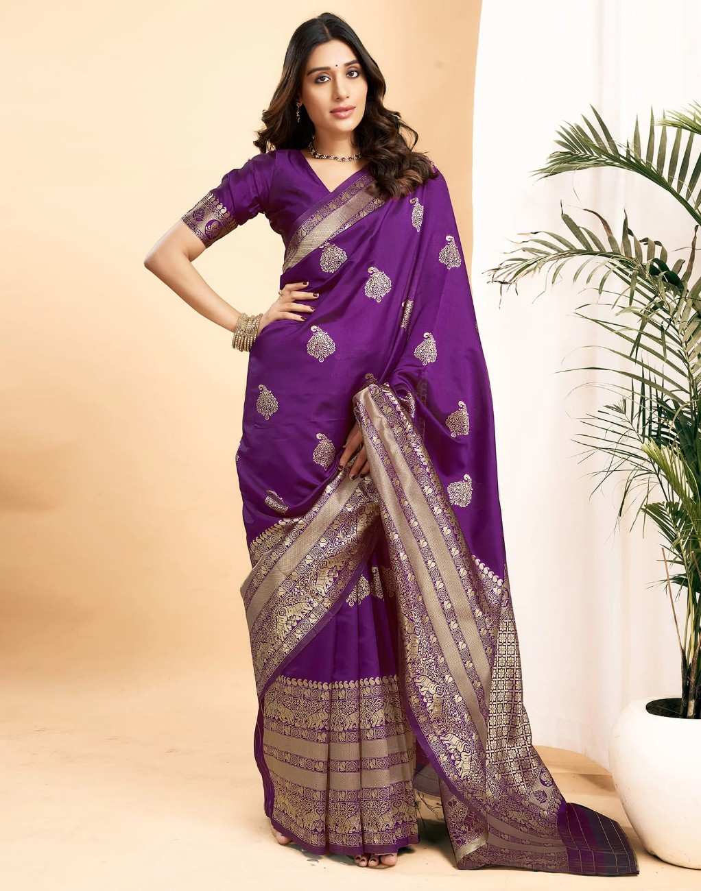 Woman wearing a purple saree with silver patterns against a beige background