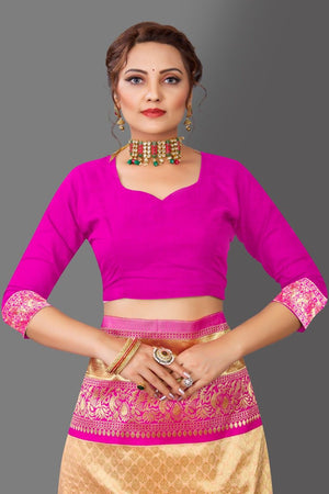 Woman wearing a bright pink blouse with gold and pink traditional skirt on a gray background